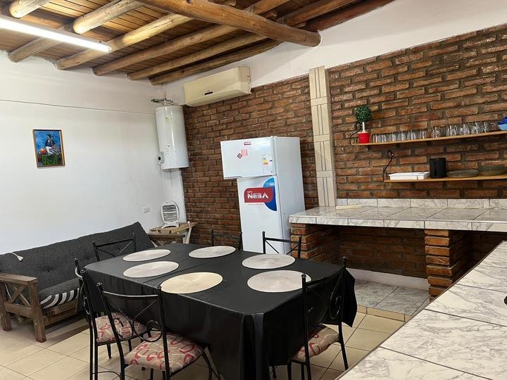 Cocina comedor con paredes de ladrillo visto y techo de madera
