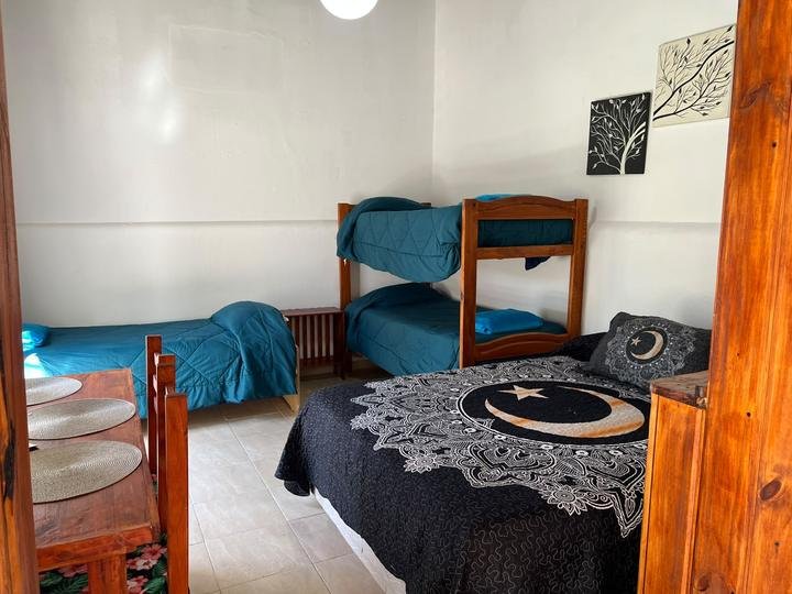 Dormitorio con cama matrimonial, cucheta y detalles de madera